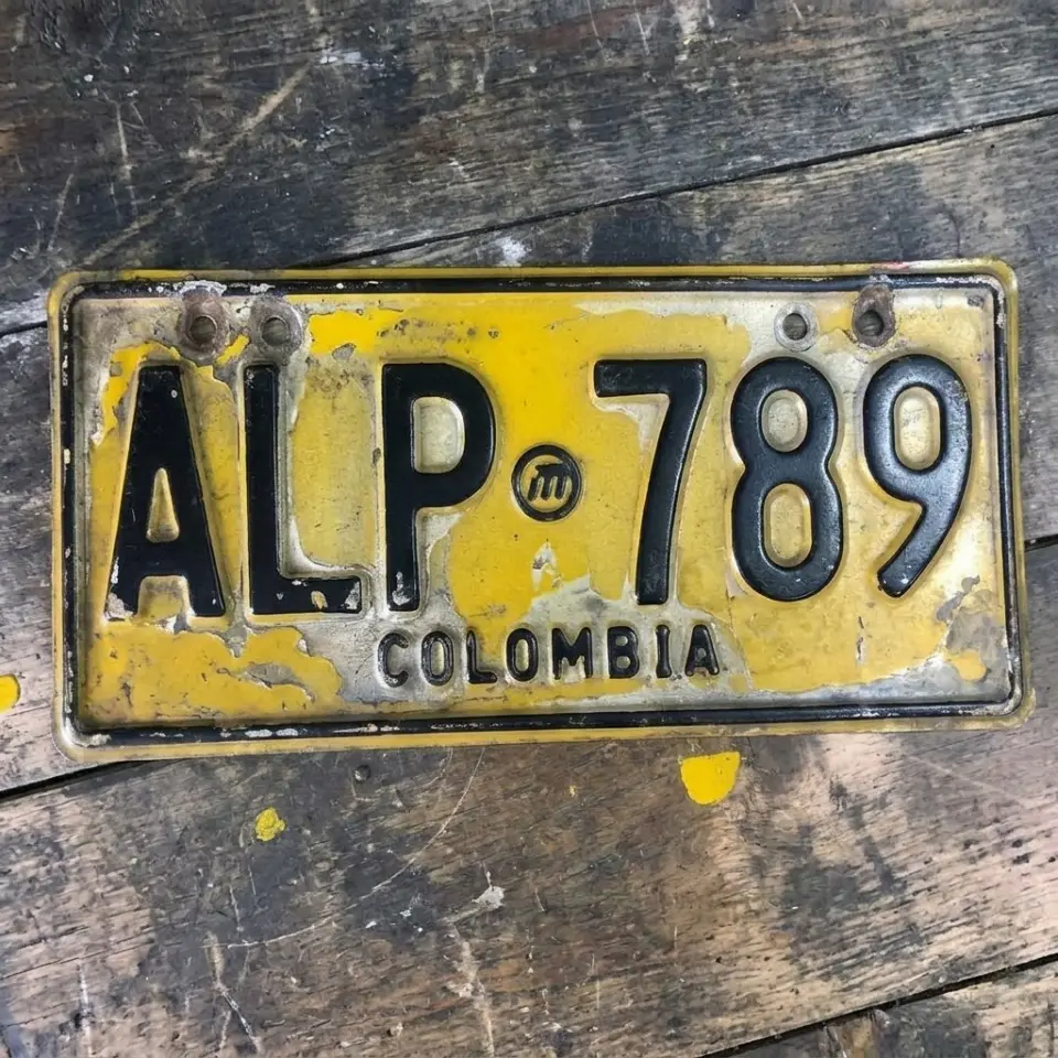 Placa vehicular ALP 789 deteriorada, con pintura desprendida y óxido, antes de la restauración
